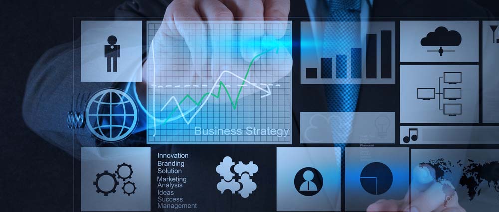 A person interacts with a digital interface displaying graphs, charts, and icons related to business strategy. The screen includes terms like innovation, branding, and marketing, along with symbols for global communication and puzzle pieces.