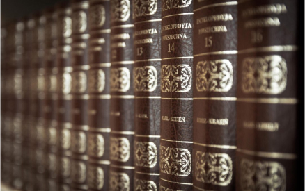 A row of brown leather-bound encyclopedias with gold embossed text on the spines, numbered sequentially from 13 to 15, arranged neatly on a shelf.