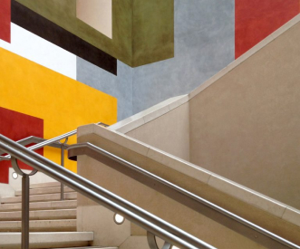 Stairs with beige steps and metallic handrails lead upward. The walls are adorned with geometric patterns in bold colors: red, yellow, and green. Rectangular and square shapes create a modern and abstract design.