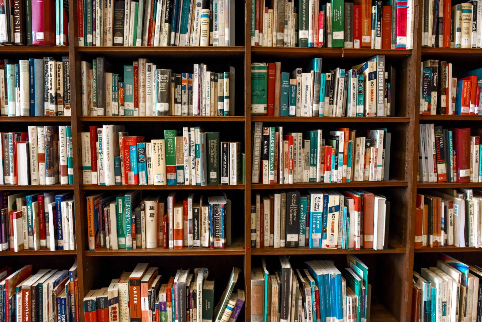 A large bookshelf filled with a diverse assortment of books. The shelves display a variety of titles and colors, creating a vibrant and inviting scene typical of a library or personal study.