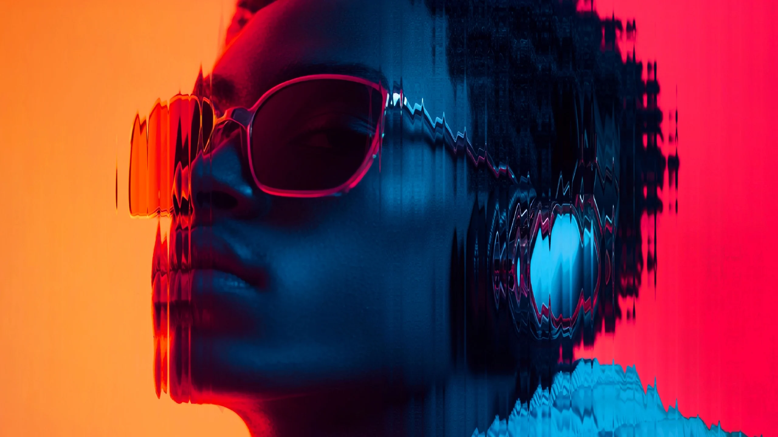 A person wearing sunglasses, with an artistic distortion effect applied to their face. The background is split into vibrant orange and blue colors, blending at the center. The image has a futuristic, abstract style.